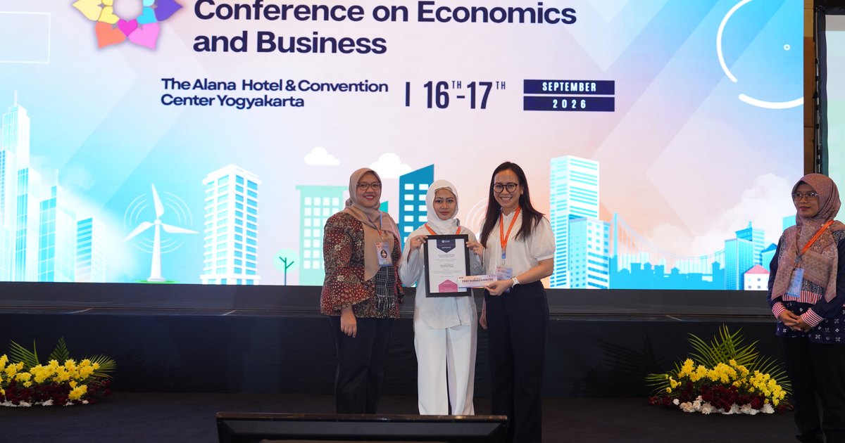 Haya Aqilah Zhafirah holding her award certificate on stage, between a representative of the Faculty of Economics and Business at Universitas Gadjah Mada on the left and Mrs. Ruth Srininta Tarigan on the right, in front of the conference backdrop.
